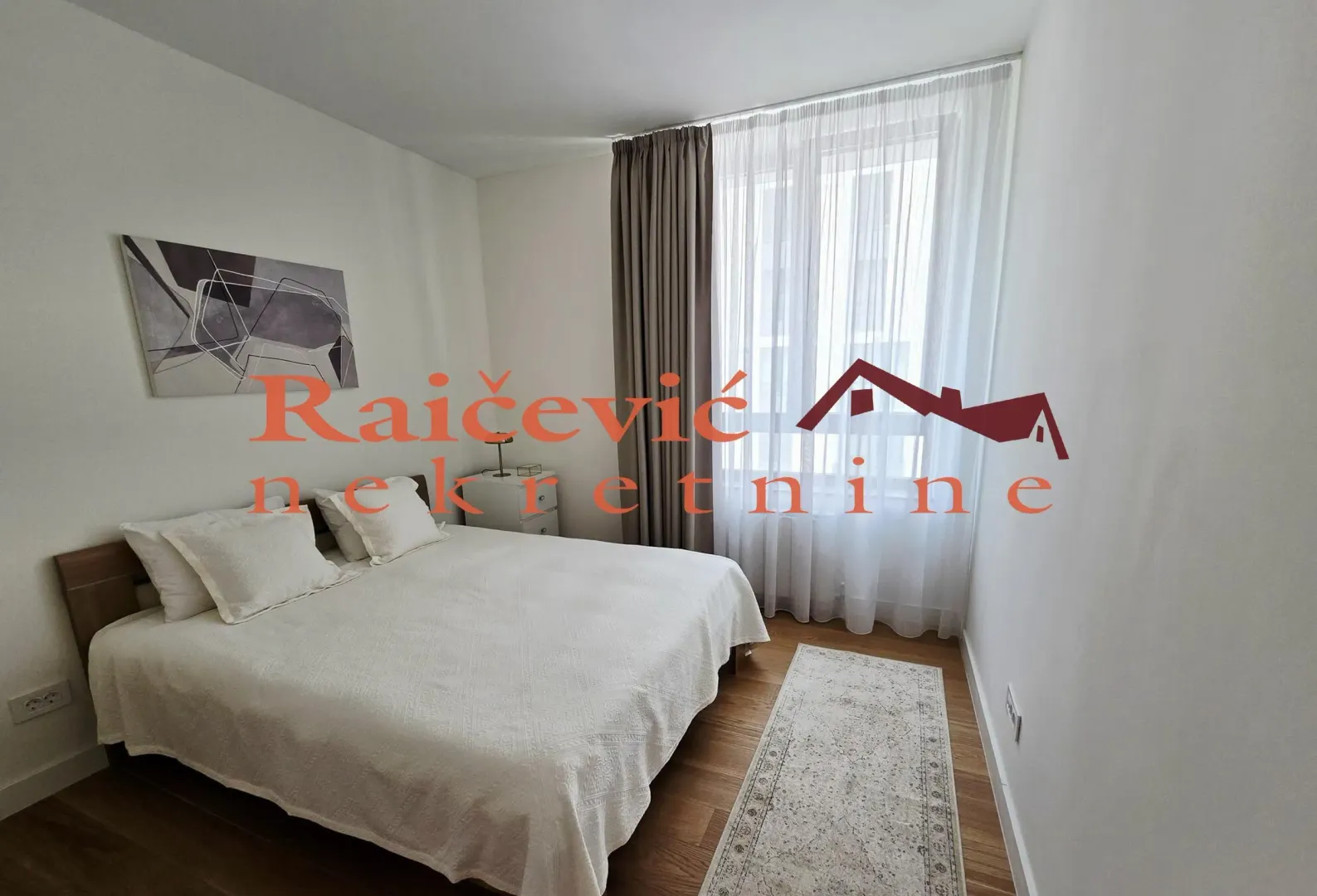 Bright bedroom with a double bed, white linens, and a window with curtains.