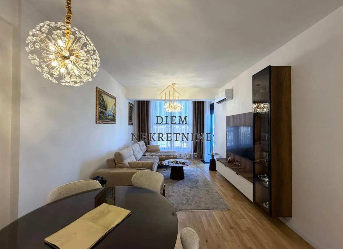 Living room with dining area and modern lighting.