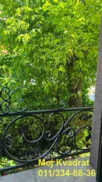 Pogled sa terase na zelene krošnje drveća i dvorište. - image 16