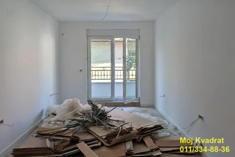 Prazna prostorija u toku renoviranja sa gomilom kartona i materijala na podu. - image 4