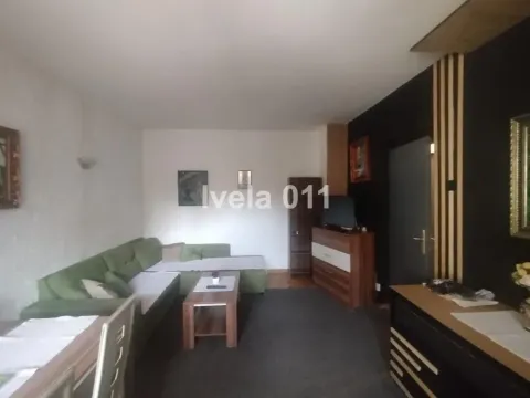 Dnevna soba sa garniturom za sedenje, televizorom i trpezarijskim stolom. - image 5