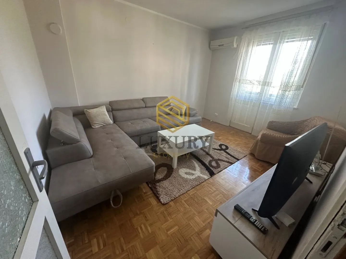 Living room with a sectional sofa, coffee table, and television.