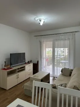 Dnevna soba sa garniturom, TV komodom i izlazom na terasu. - image 2