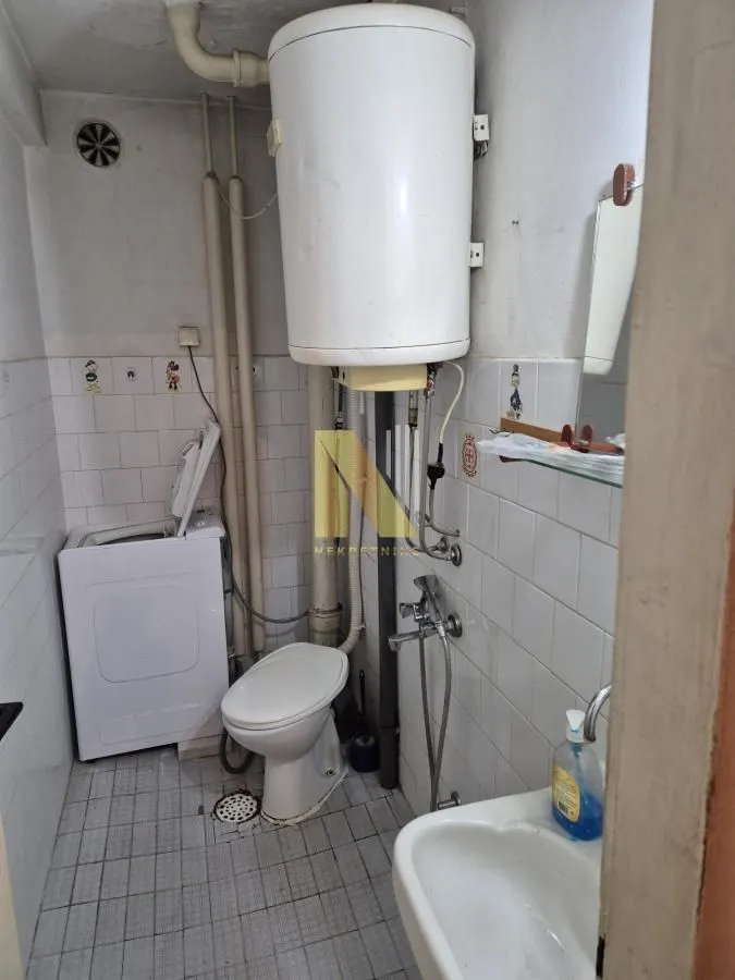 Manje kupatilo sa sanitarijama, bojlerom i veš mašinom.