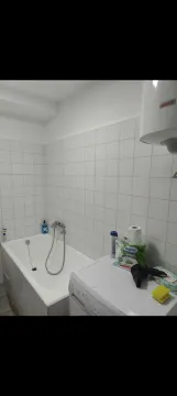 Manje kupatilo sa kadom, bijelim pločicama i mašinom za veš. - image 4
