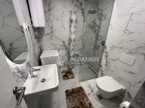 Modern bathroom with a walk-in shower, washbasin, and toilet, finished with marble tiles. - image 9