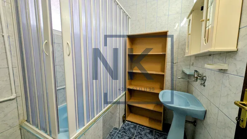 Small equipped bathroom with a shower cabin and a sink.