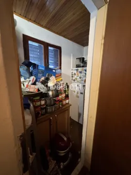 Small kitchen with a refrigerator, cabinets, and stored food items. - image 9