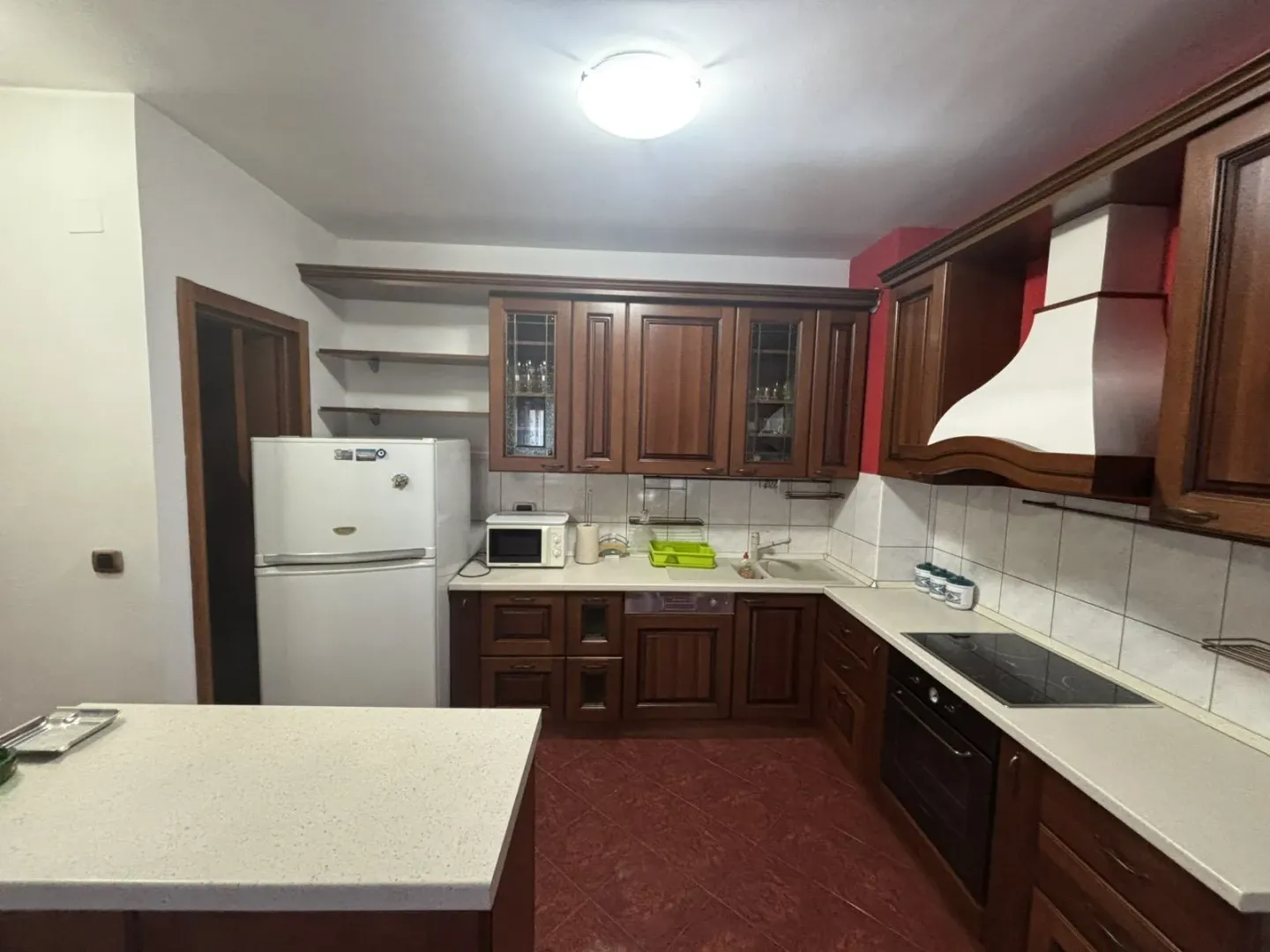 Kitchen with dark wooden cabinets and white appliances.
