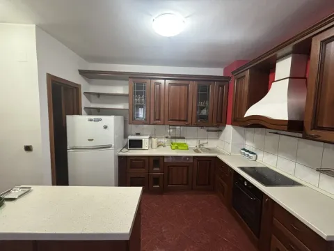 Kitchen with dark wooden cabinets and white appliances. - image 4