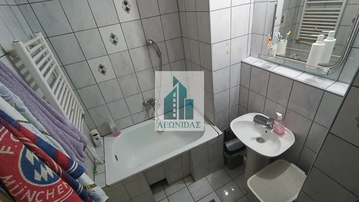 Bathroom equipped with a bathtub, washbasin, toilet, and wall tiles.