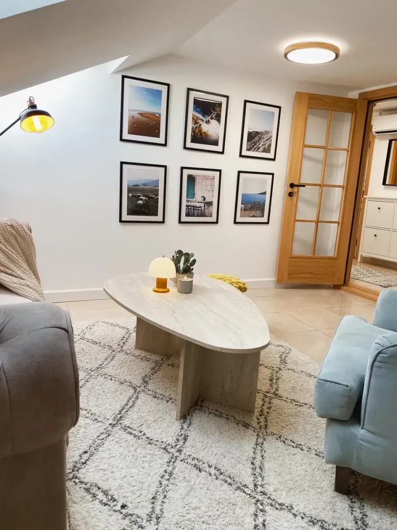 Cozy living room with a sofa, coffee table, and framed pictures on the wall.