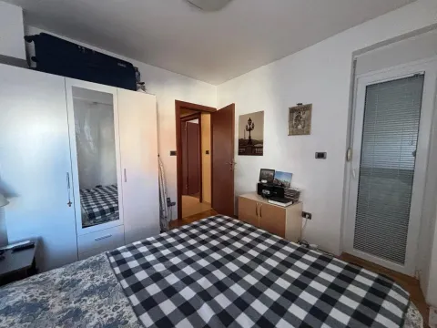Namještena spavaća soba sa bračnim krevetom, bijelim garderoberom i izlazom na terasu. - image 5