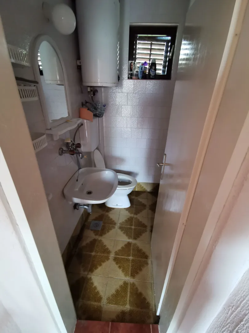 Manje kupatilo sa umivaonikom, WC šoljom i bojlerom.