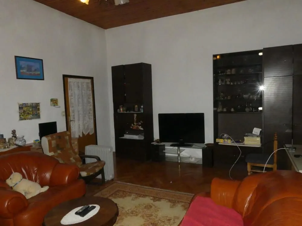Living room with leather furniture sets and dark wood cabinetry.