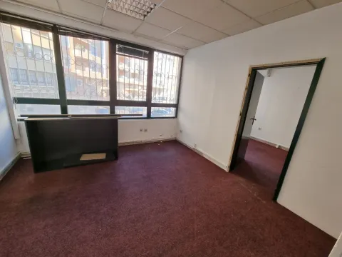 An empty room with large windows and dark carpeting. - image 8