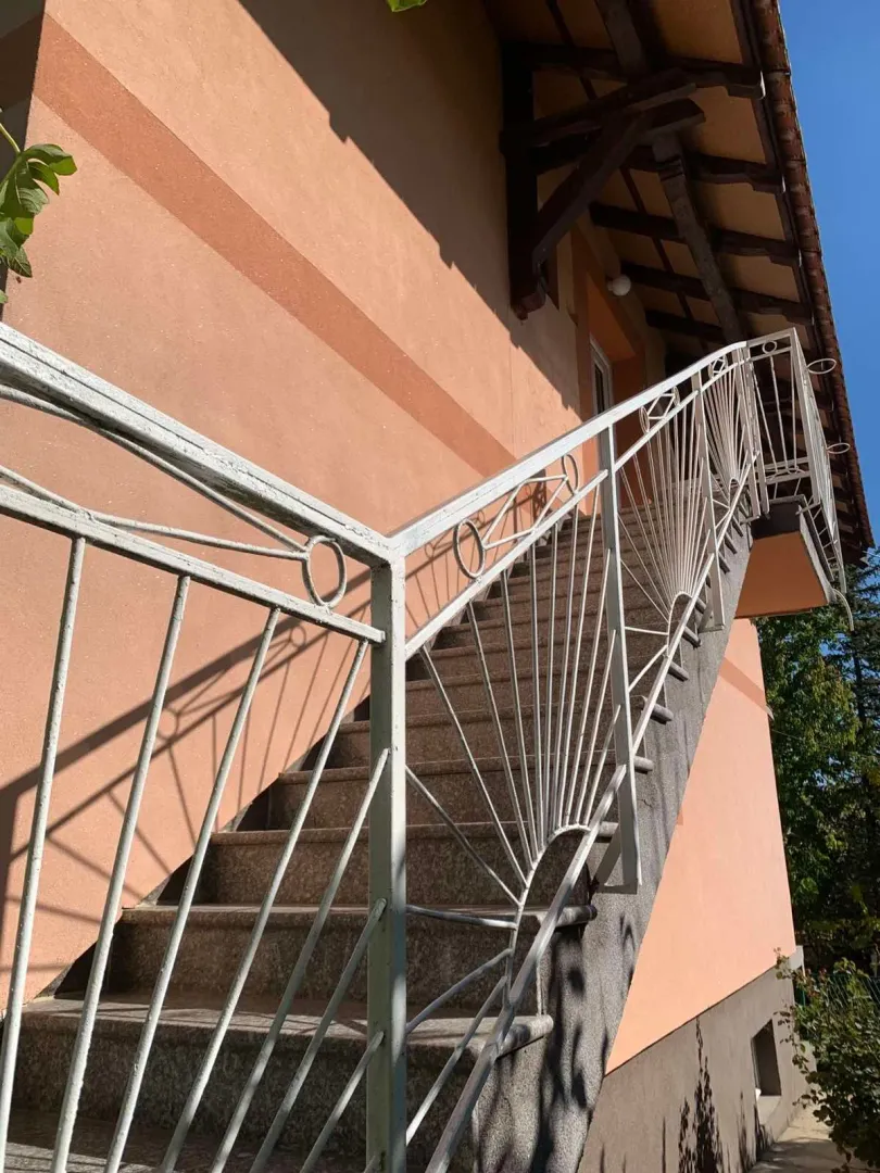 External staircase with a white railing on the side of the house.