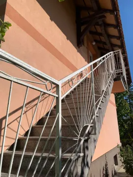 External staircase with a white railing on the side of the house. - image 16