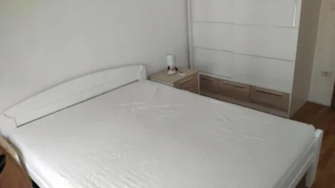 Bedroom with a double bed, bedside table, and wardrobe. - image 13