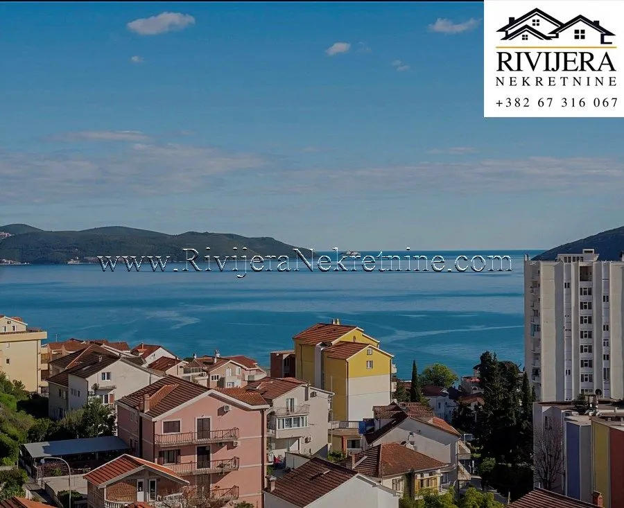 Pogled sa prozora na more i gradske krovove.