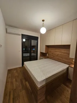 Modern bedroom with a double bed, built-in wardrobe, and wooden flooring. - image 8