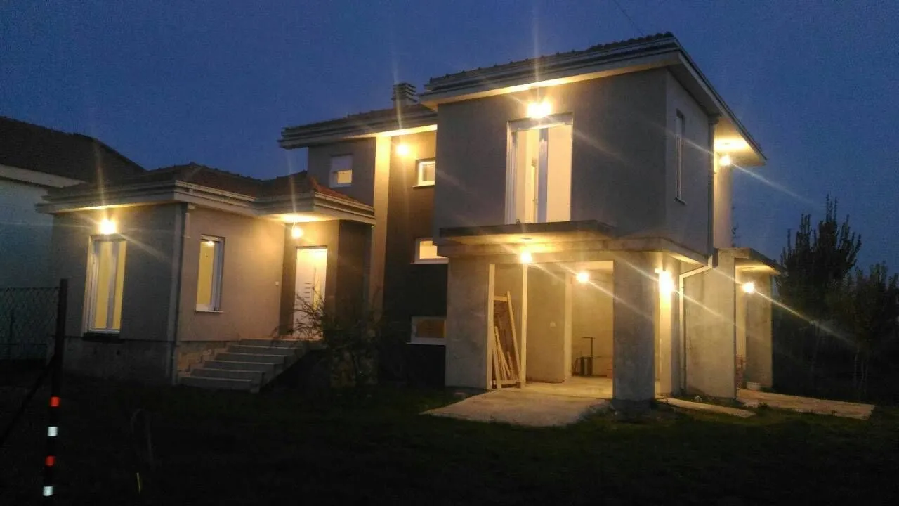 Exterior view of an illuminated modern house at night.