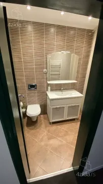 View of the bathroom with a washbasin, mirror, and toilet. - image 21