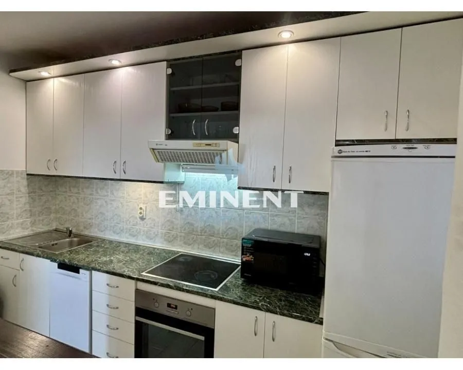 Kitchen equipped with white cabinetry and appliances.