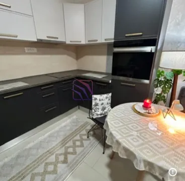 Moderna kuhinja sa tamnim i bijelim elementima i trpezarijskim stolom. - image 7