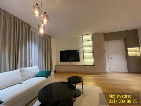 Living room with a sofa, TV, and modern lighting. - image 6