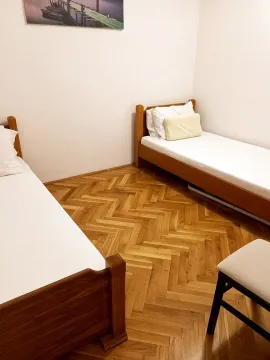 Bedroom with two wooden beds and parquet flooring. - image 5
