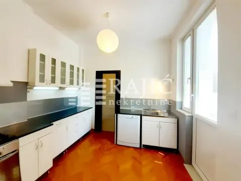 Prikaz svetle kuhinje sa belim elementima i drvenim podom. - image 17