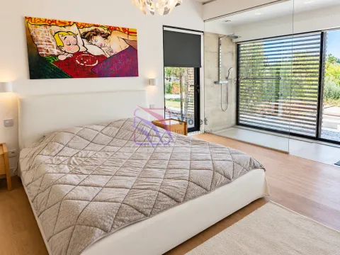 Modern bedroom with a double bed and an open-concept bathroom enclosed by glass partitions. - image 4
