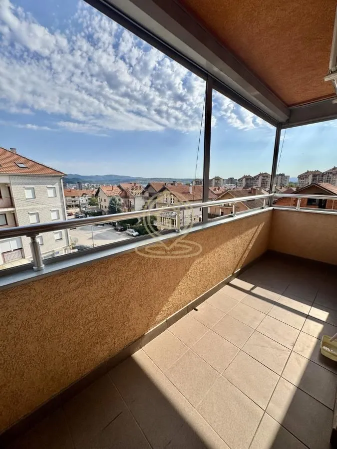 Covered balcony with a metal railing and a view of the town.