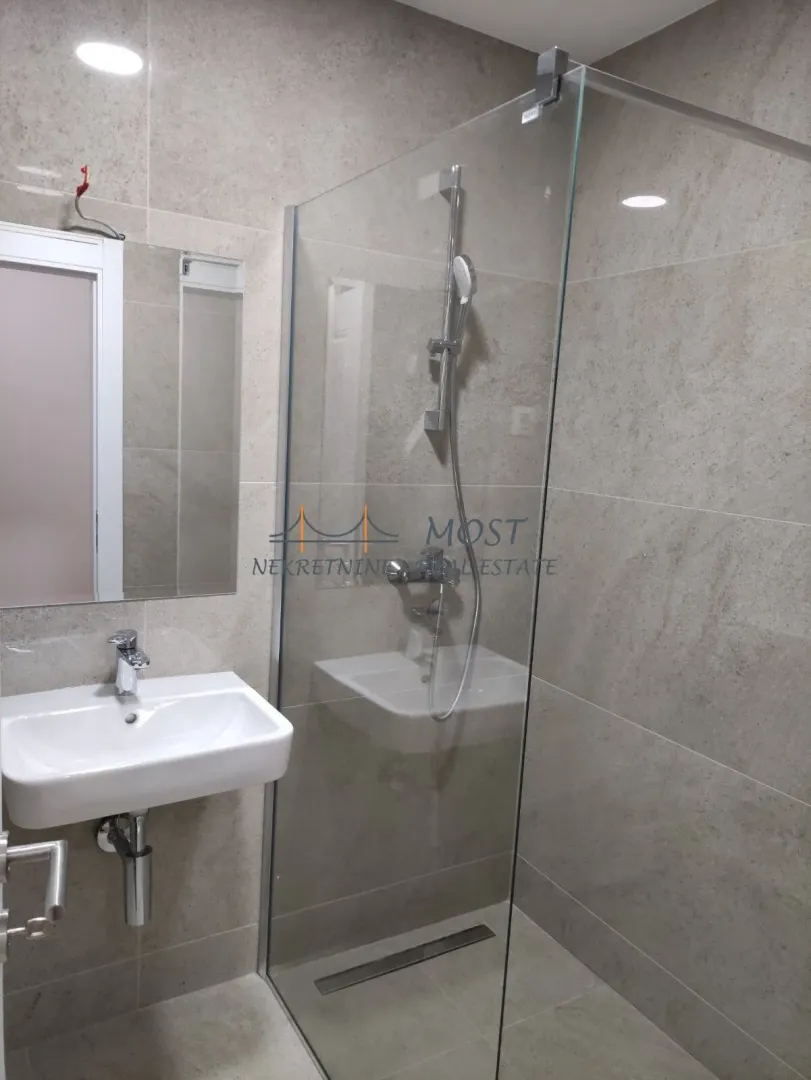 Modernly equipped bathroom with a walk-in shower and washbasin.