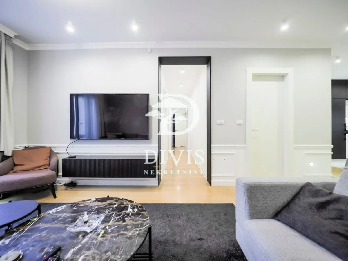 Modern living room with seating area, TV and coffee table.