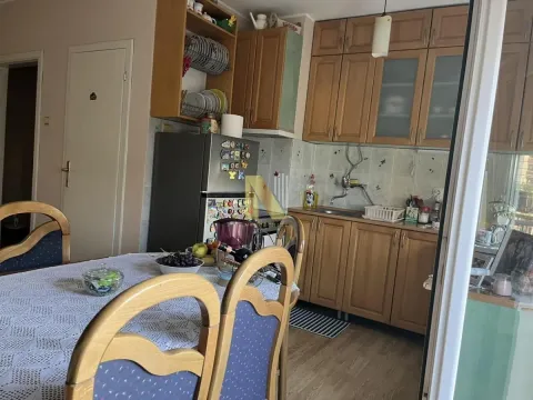 Kuhinja sa drvenim elementima i trpezarijskim stolom. - image 3