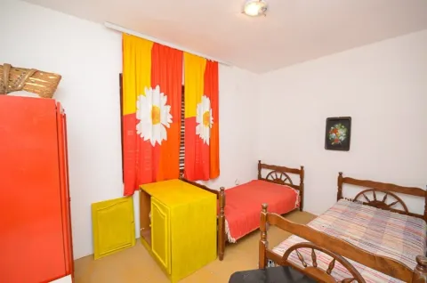 Spavaća soba sa dva kreveta i živopisnim namještajem. - image 15
