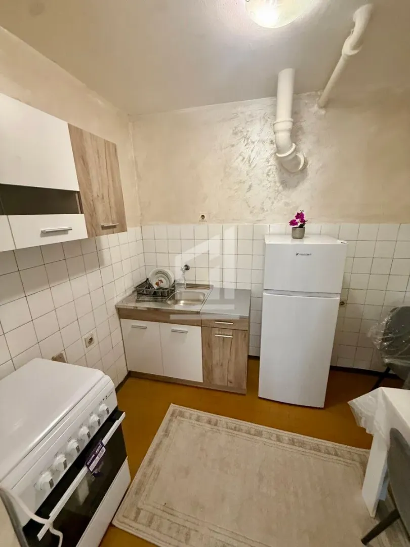 Manja kuhinja sa sudoperom, frižiderom i šporetom.