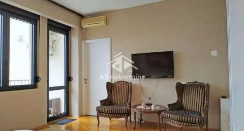 Living room with armchairs, a small table, and a wall-mounted TV. - image 10