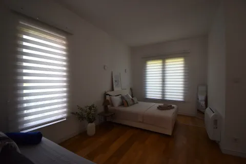 Uređena spavaća soba sa bračnim krevetom i dva prozora. - image 7