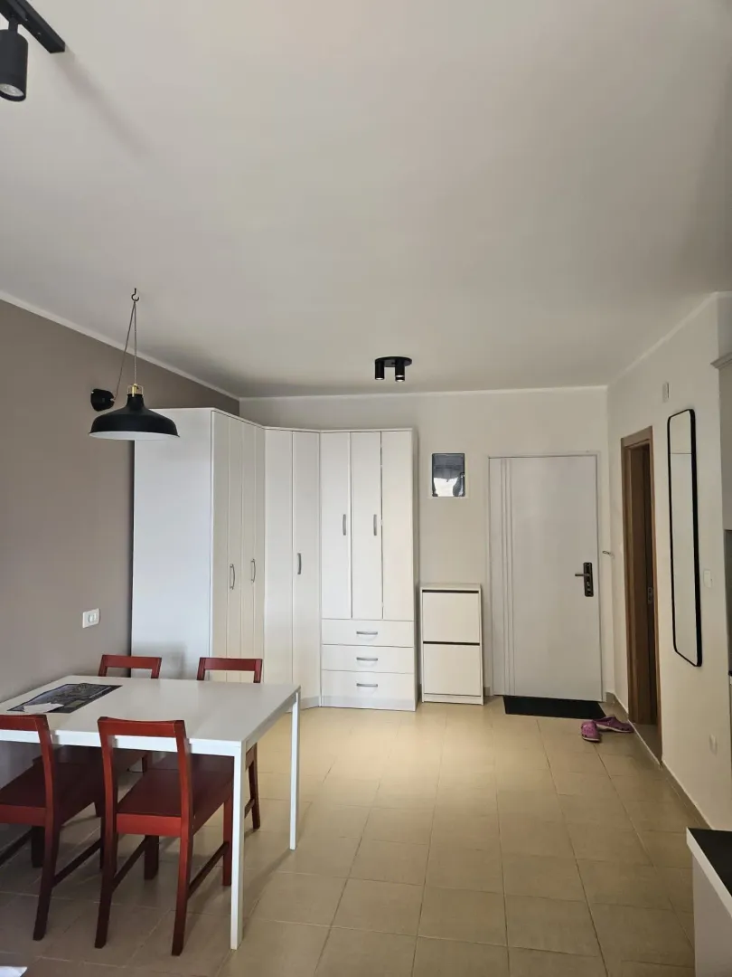 Living room with a dining table and white wardrobe near the entrance door.