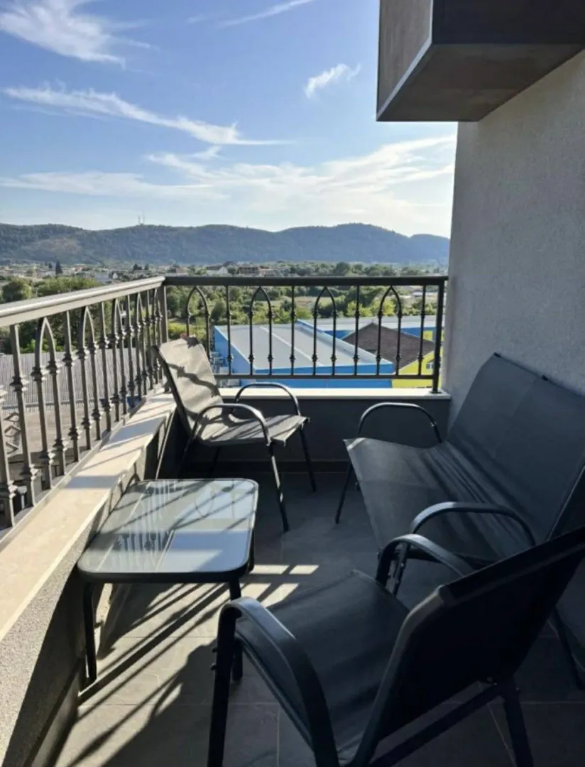 Furnished balcony with seating set and view of the surroundings.