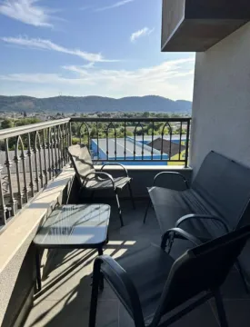 Furnished balcony with seating set and view of the surroundings. - image 3
