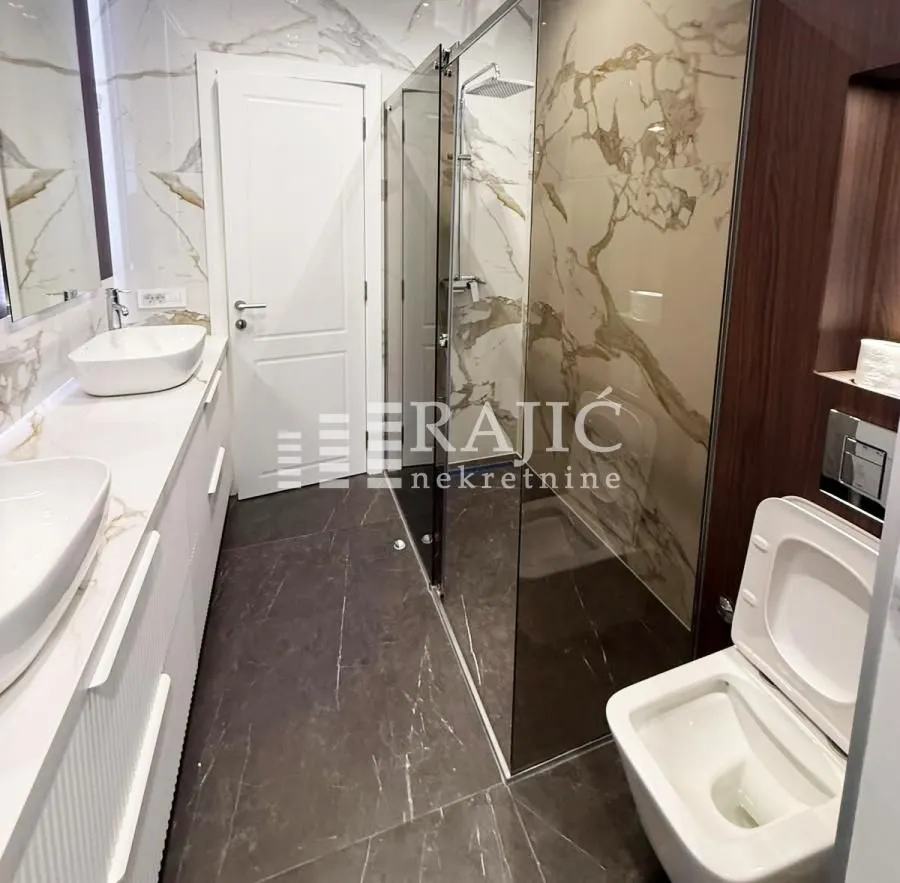 Modern bathroom equipped with a walk-in shower and washbasin.