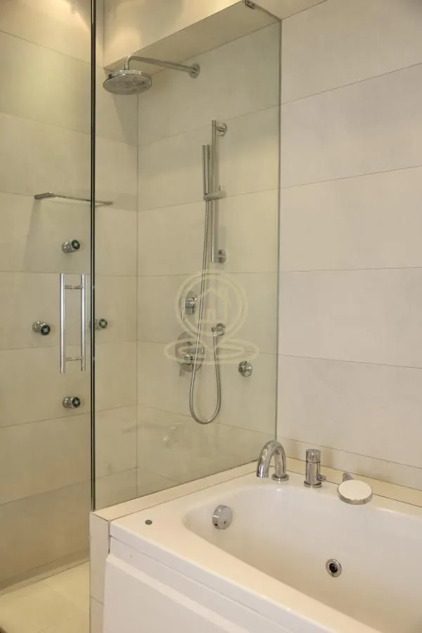 Bathroom with a shower cabin and a bathtub.