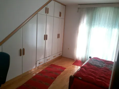 Svijetla spavaća soba sa ugradnim plakarom ispod kosine i crvenim detaljima. - image 8