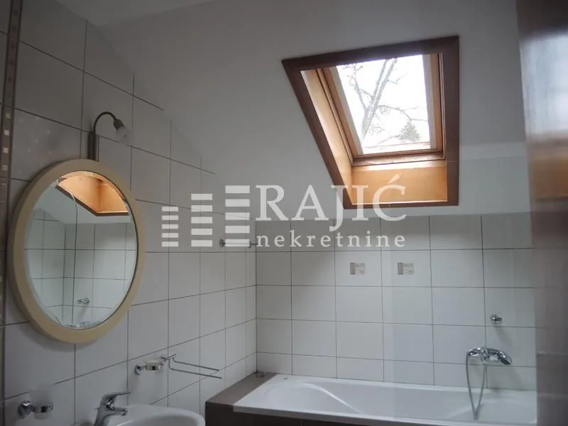 Bathroom with bathtub, washbasin and skylight.