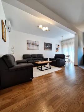 Dnevna soba sa garniturom za sjedenje, drvenim podom i modernim osvjetljenjem. - image 2