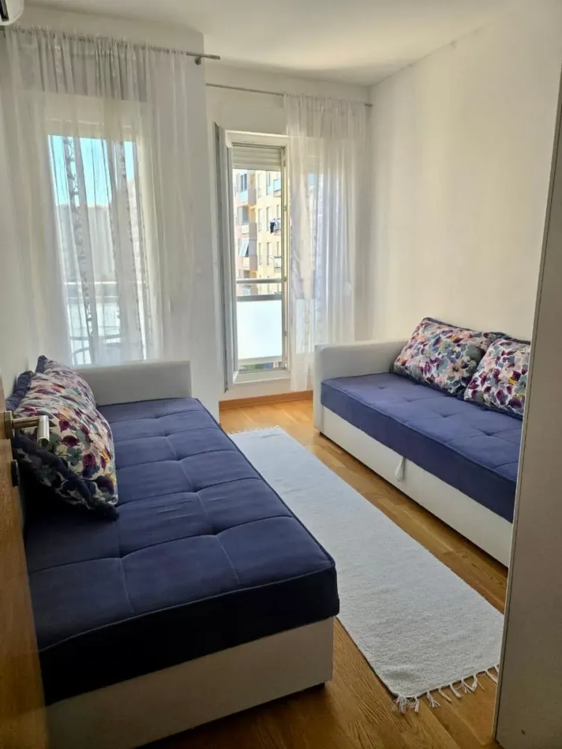 Dnevna soba sa dva kauča i izlazom na balkon.